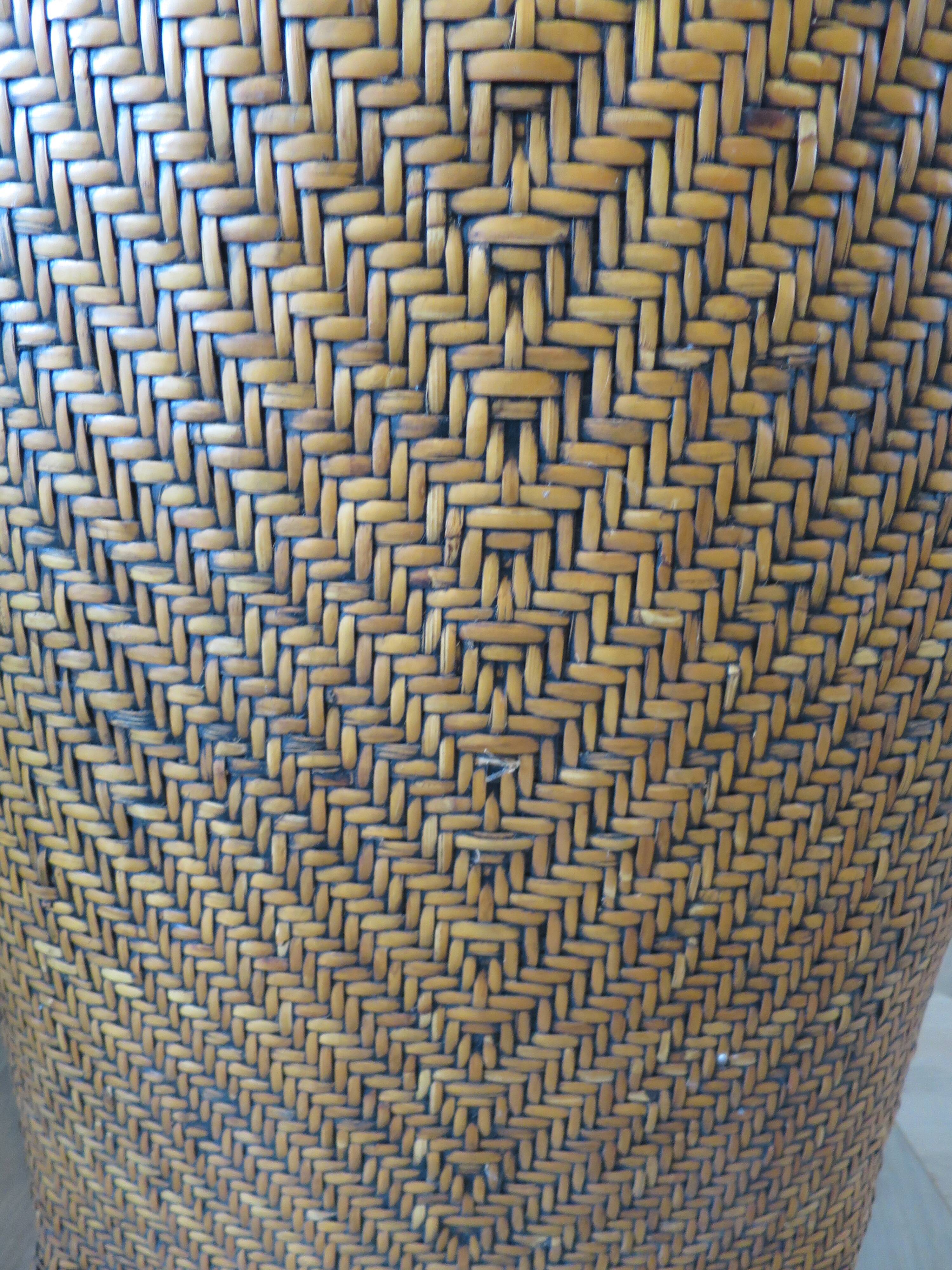 Colonial style armchair in woven rattan and exotic wood