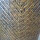 Colonial style armchair in woven rattan and exotic wood