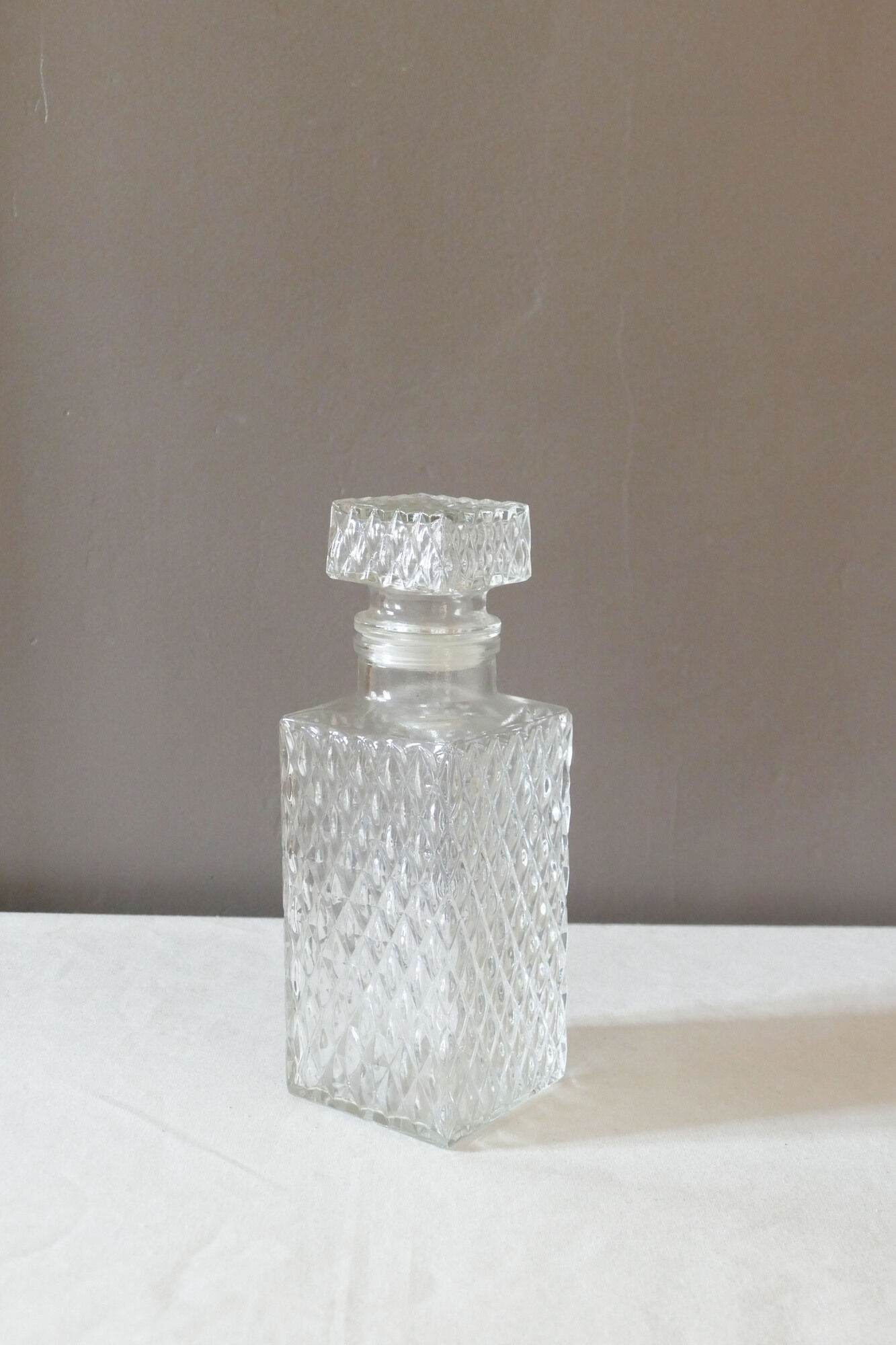 Transparent vintage decanter in chiseled glass and its hermetic cap 70's years