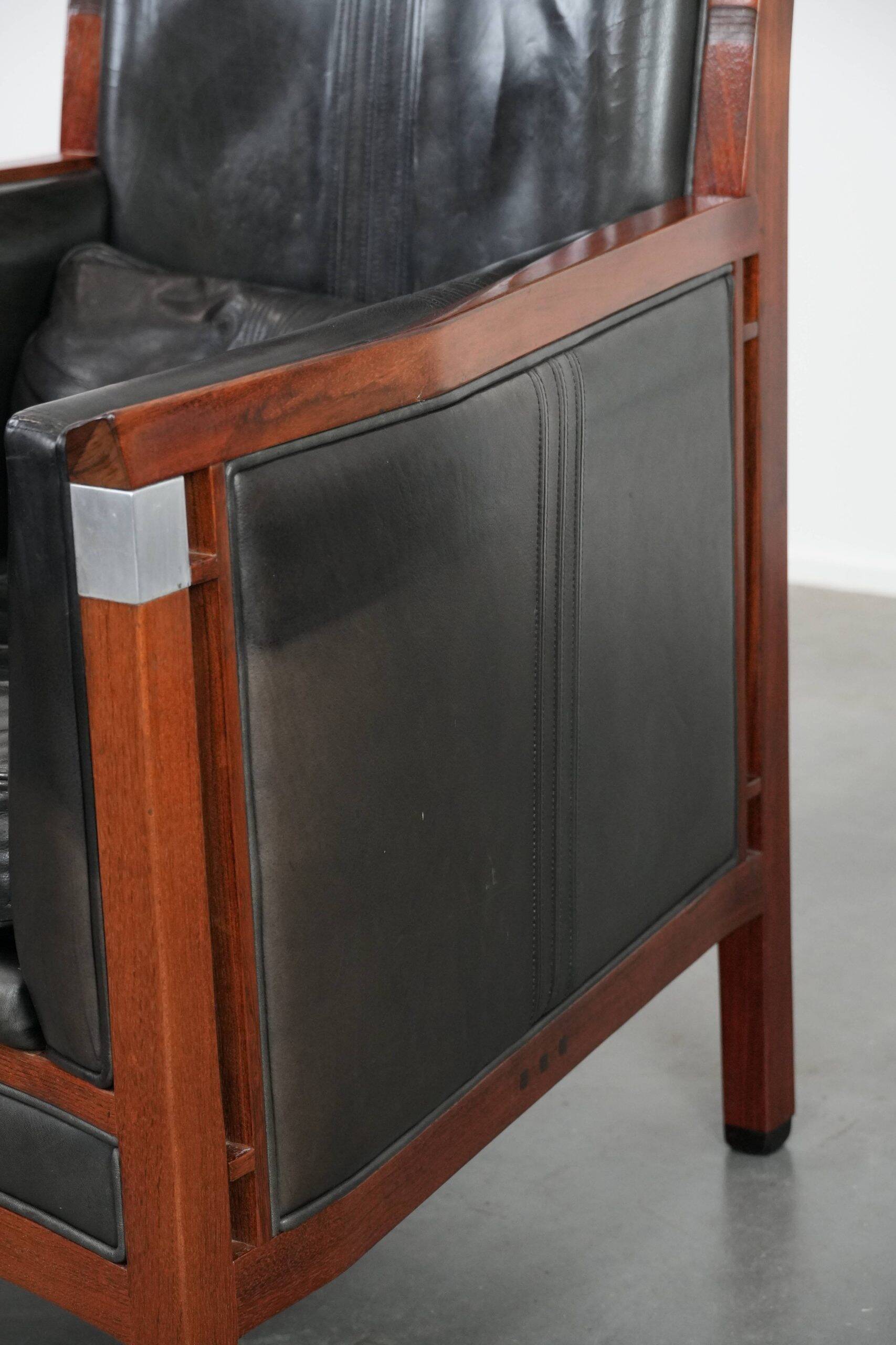 Black cowhide leather and wooden Art Deco design armchair