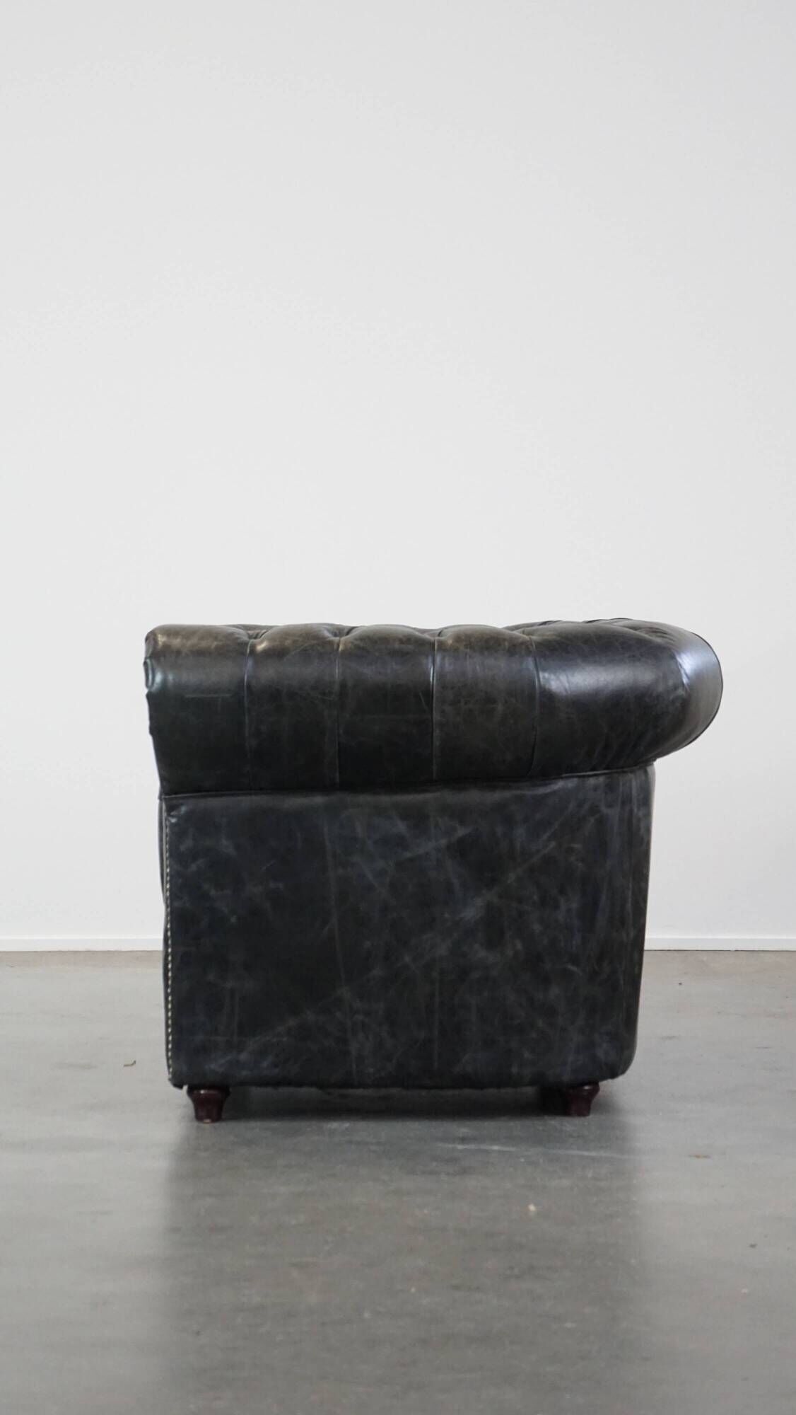 Spacious black cow leather chesterfield armchair with distinctive character
