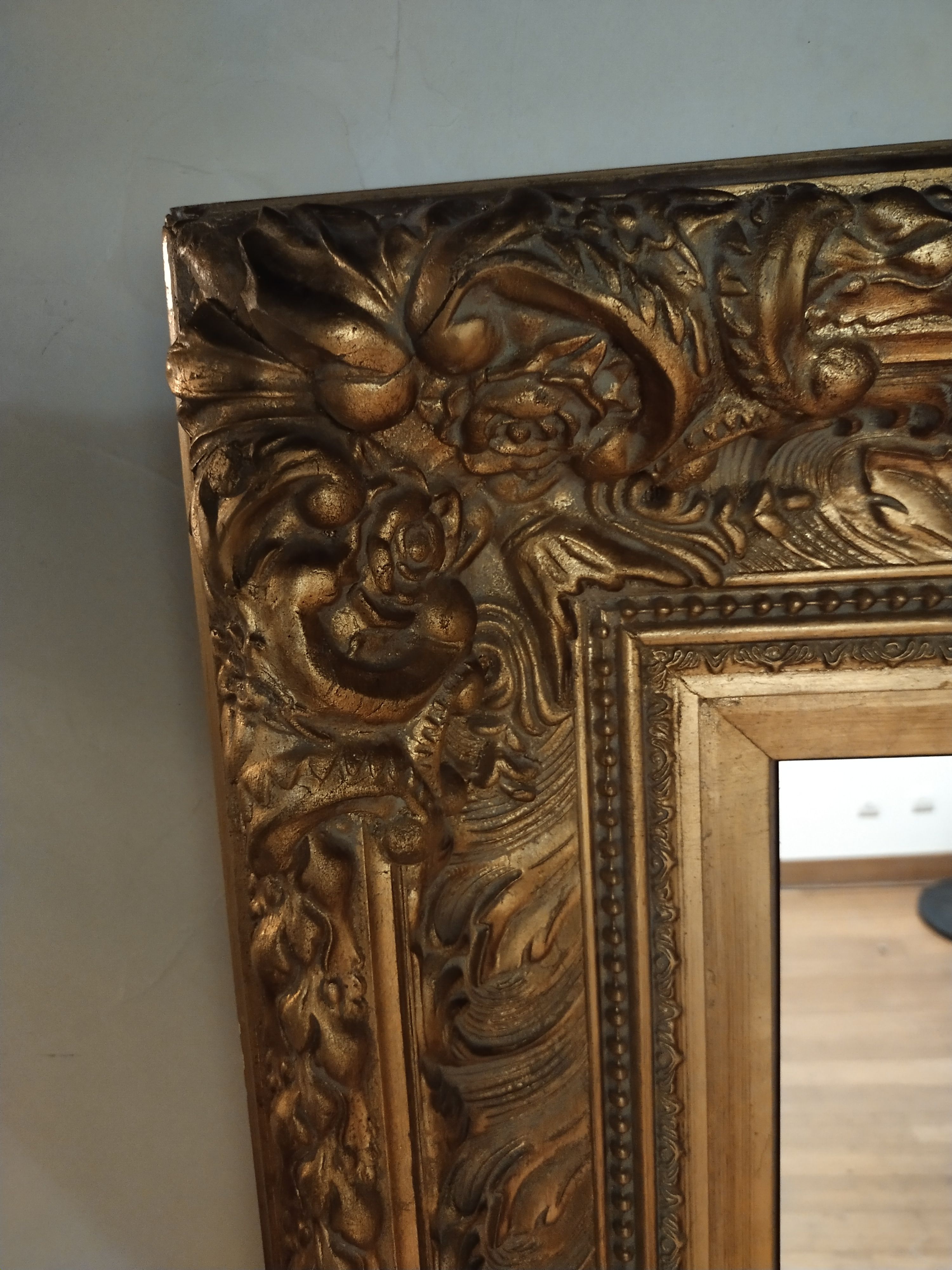 Mirror with large molded frame in gilded plaster with gold leaf