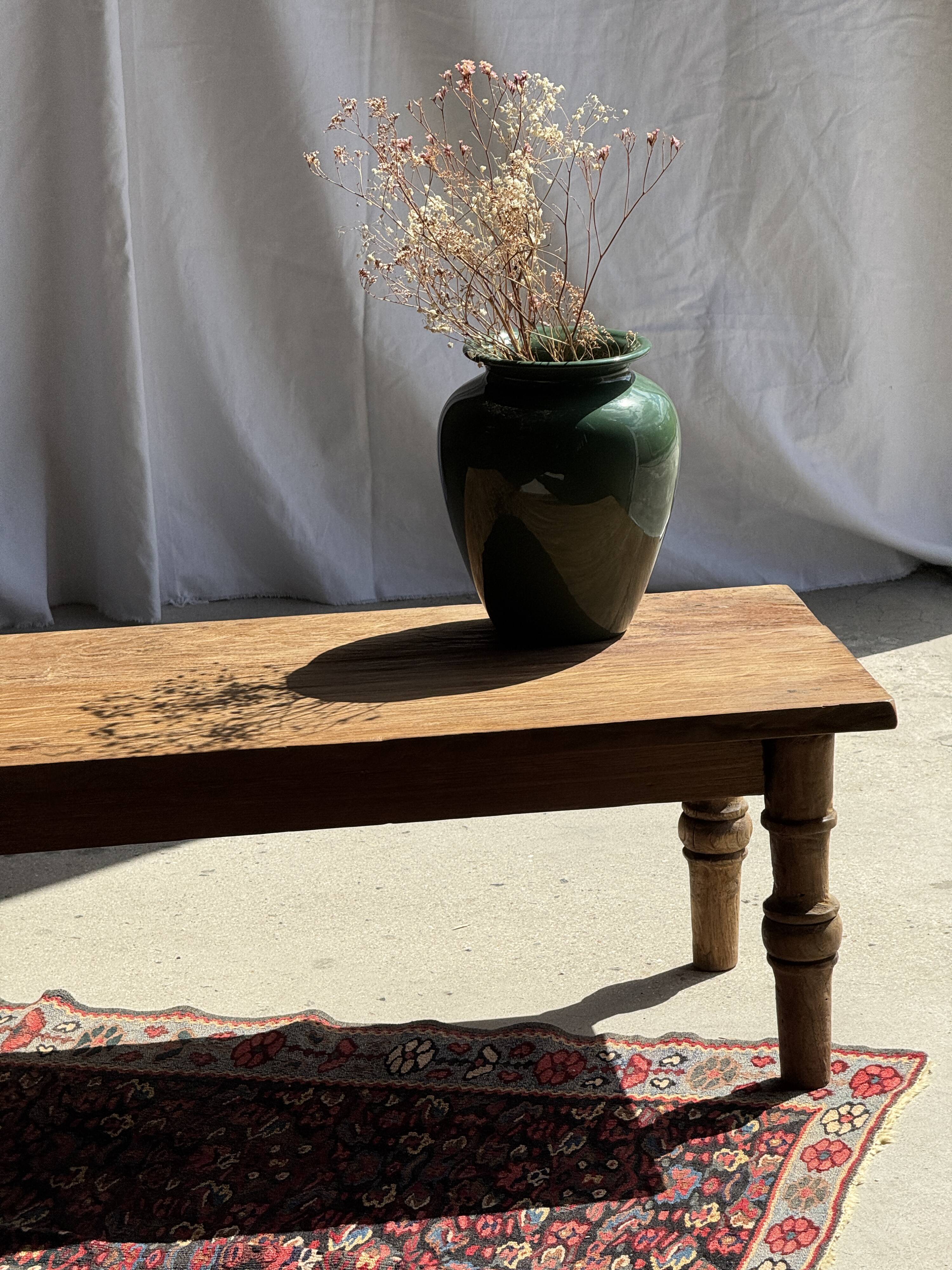 Brown Indonesian teak coffee table, with a border and cylindrical legs H40 L103.