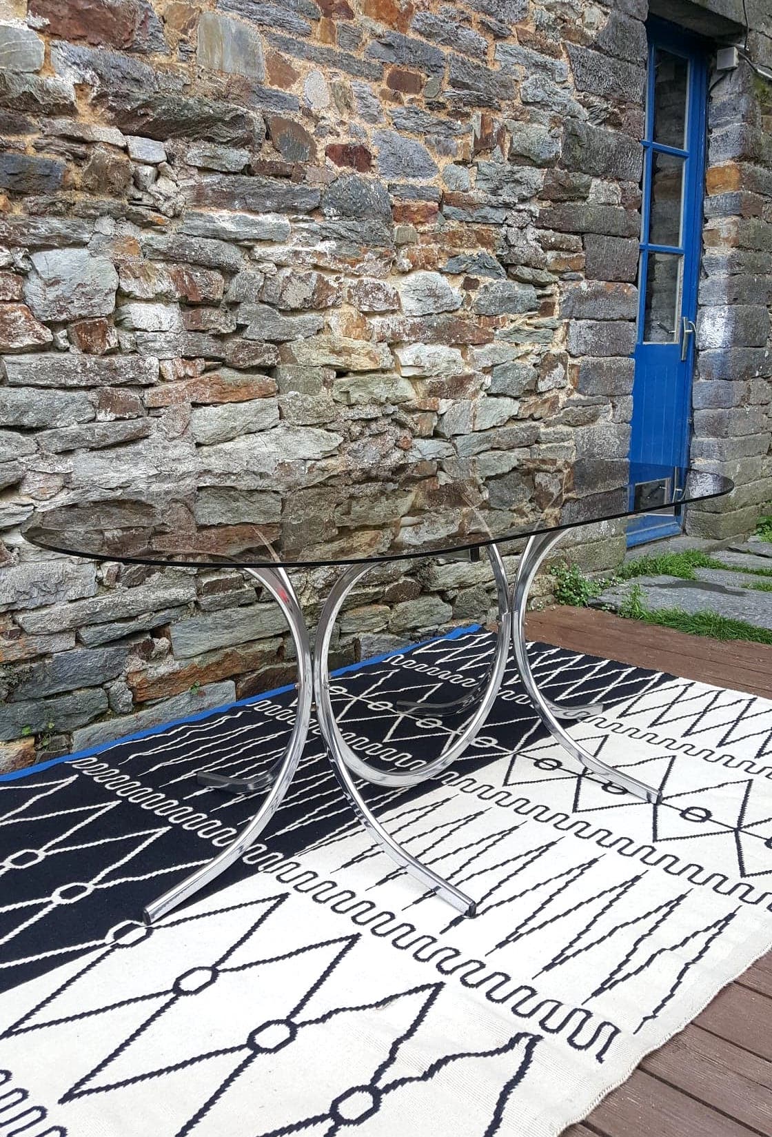 Oval table in smoked glass and metal foot