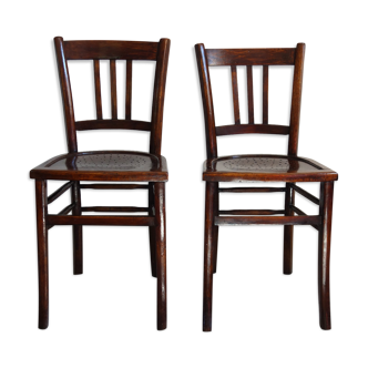 Pair of vintage bistro chairs sitting with holes