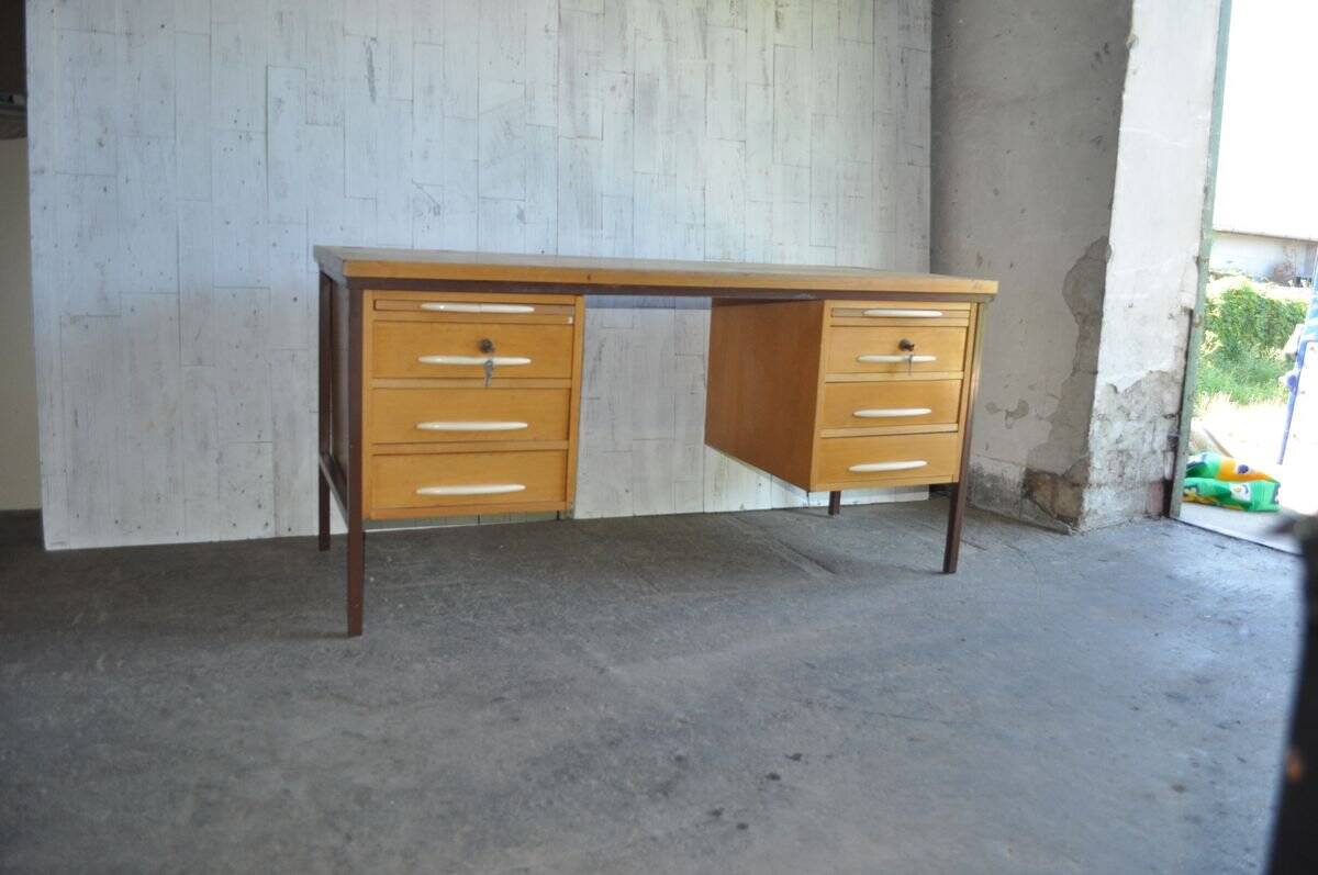 Mid-century Hungarian brown wooden desk with symmetrical drawers and white handles.