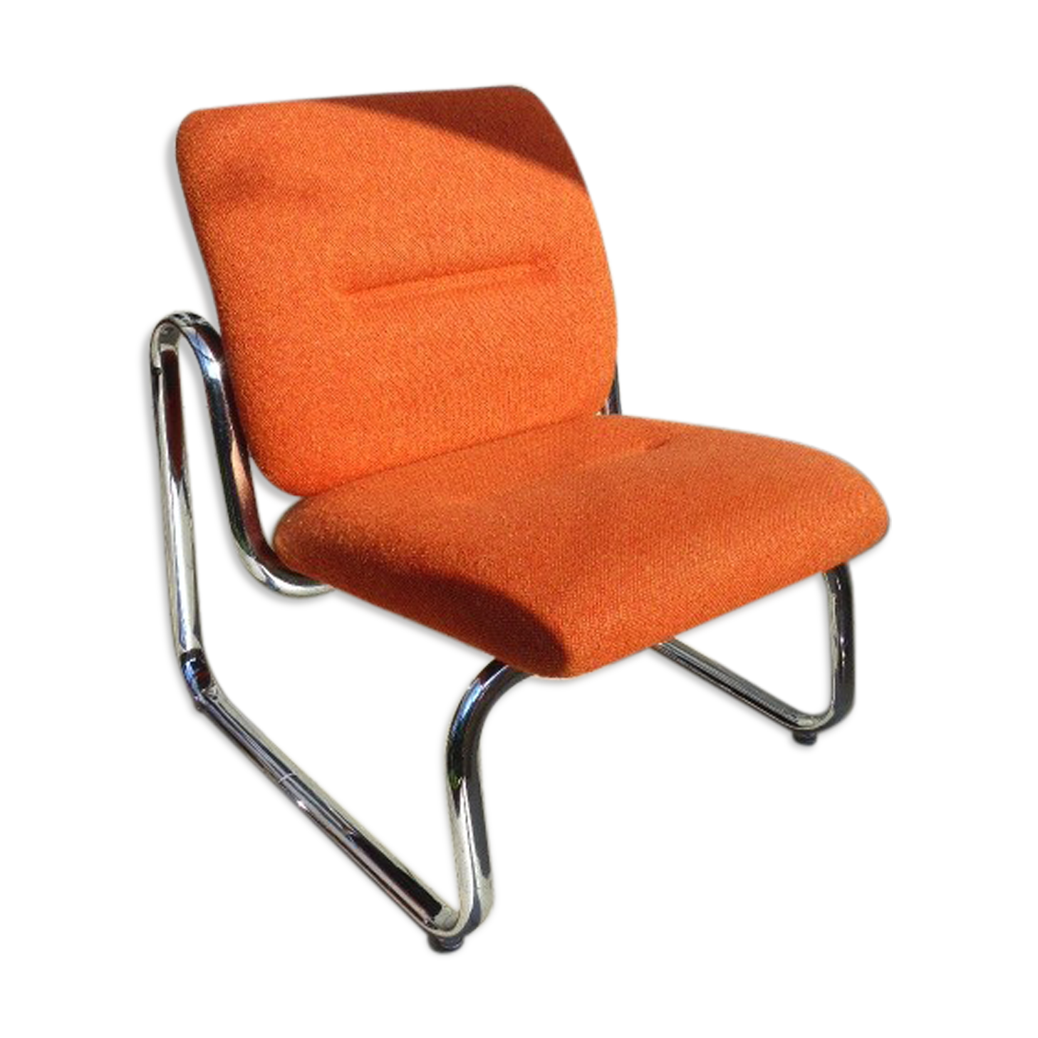 The 1970s orange armchair fabric and chrome metal