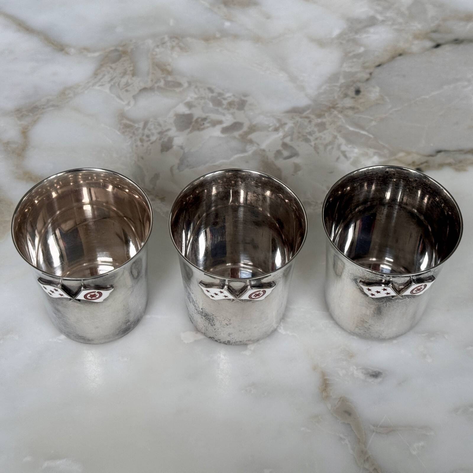 Set of 3 small silver 970 sterling cups with enamelled flags from the 20th century.