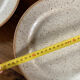 Four beige speckled plates