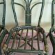 Round rattan table with glass top and 4 green rattan chairs.