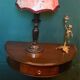 Antique half-moon side table in wood and black.