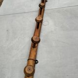 Old rustic wooden coat rack turned in imitation of bamboo