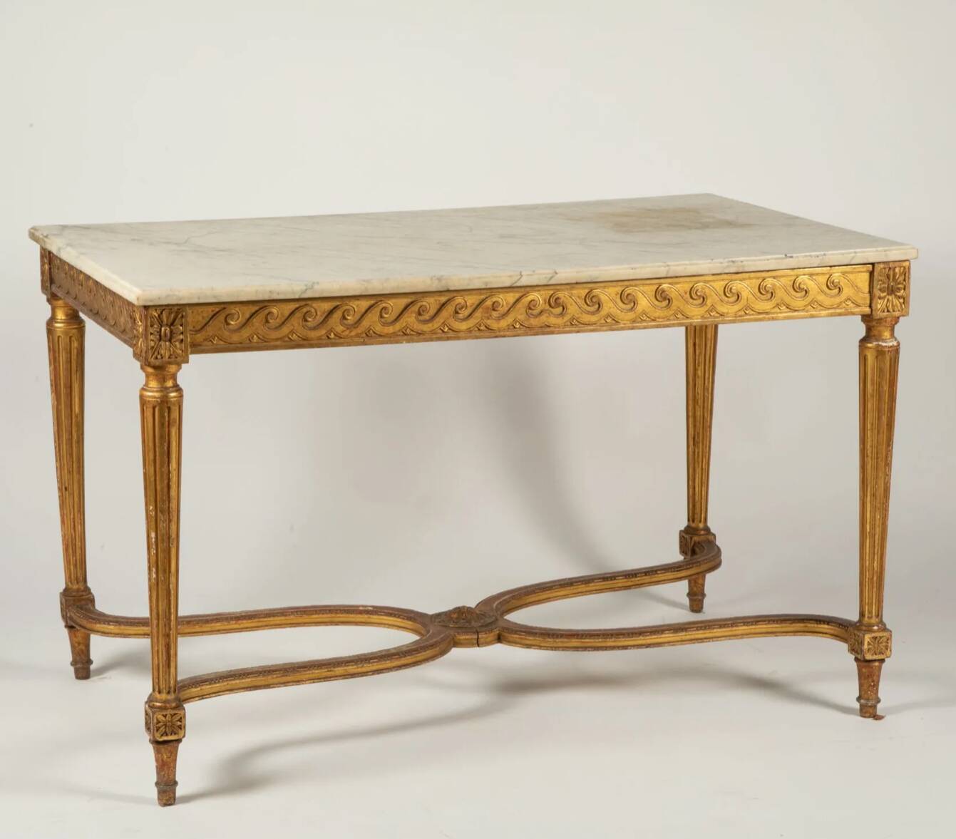 Golden carved wooden centre table with a white marble top.