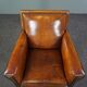 Art deco armchair in sheepskin with black piping and decorative nails