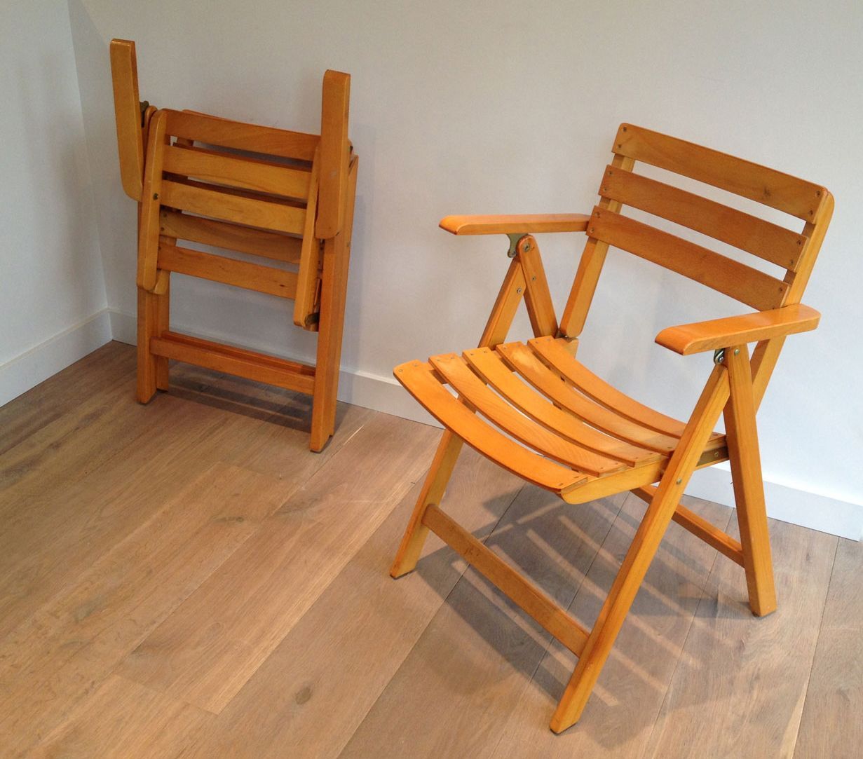 Pair of varnished wooden folding armchairs signed Clairitex.