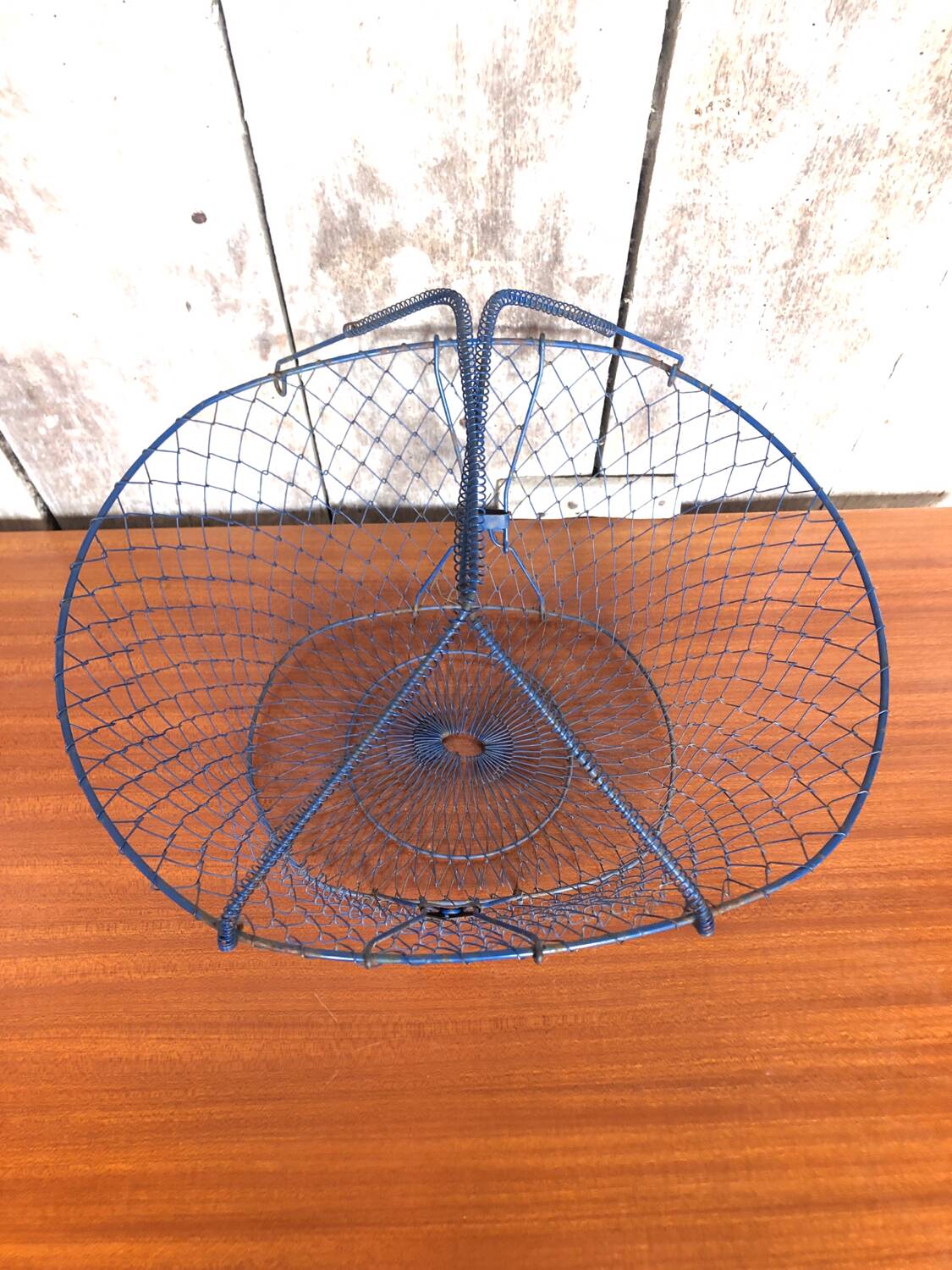 Old foldable blue metal basket, vintage handles