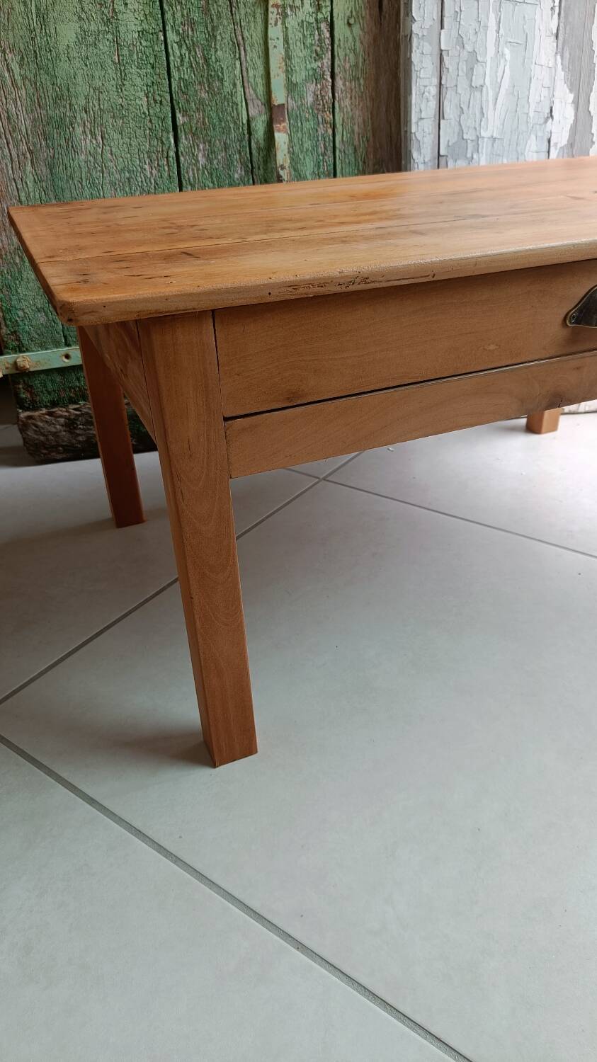 Coffee table with raw wood and a large drawer.