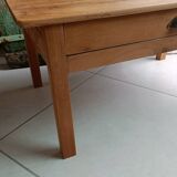 Coffee table with raw wood and a large drawer.