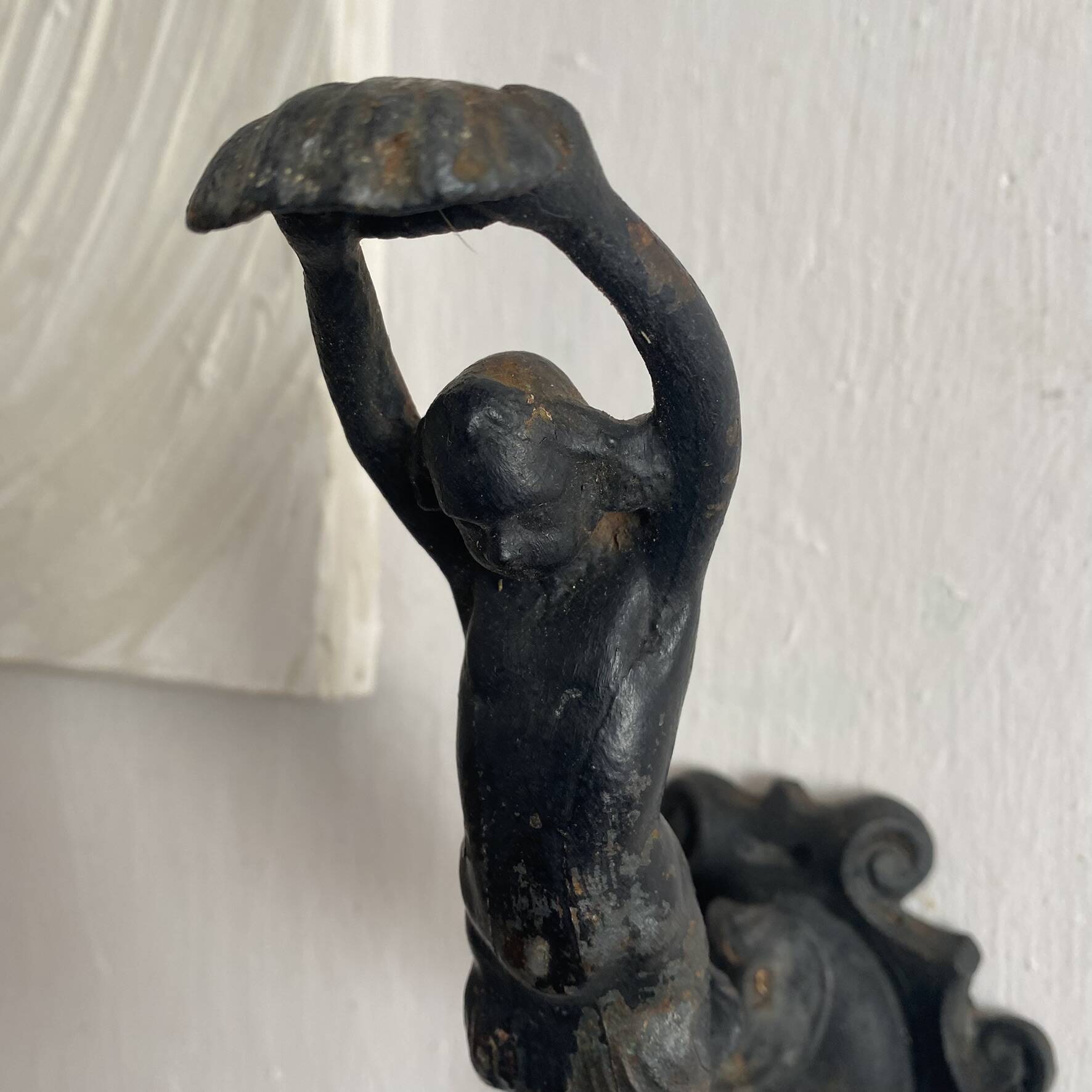 Antique cast iron coat hook with swimmer and shell basin.
