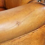 Comfortable, cozy armchair made of sheepskin leather with a neat finish and decorative nailhead trim