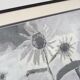 Framed painting with gray flower decor.
