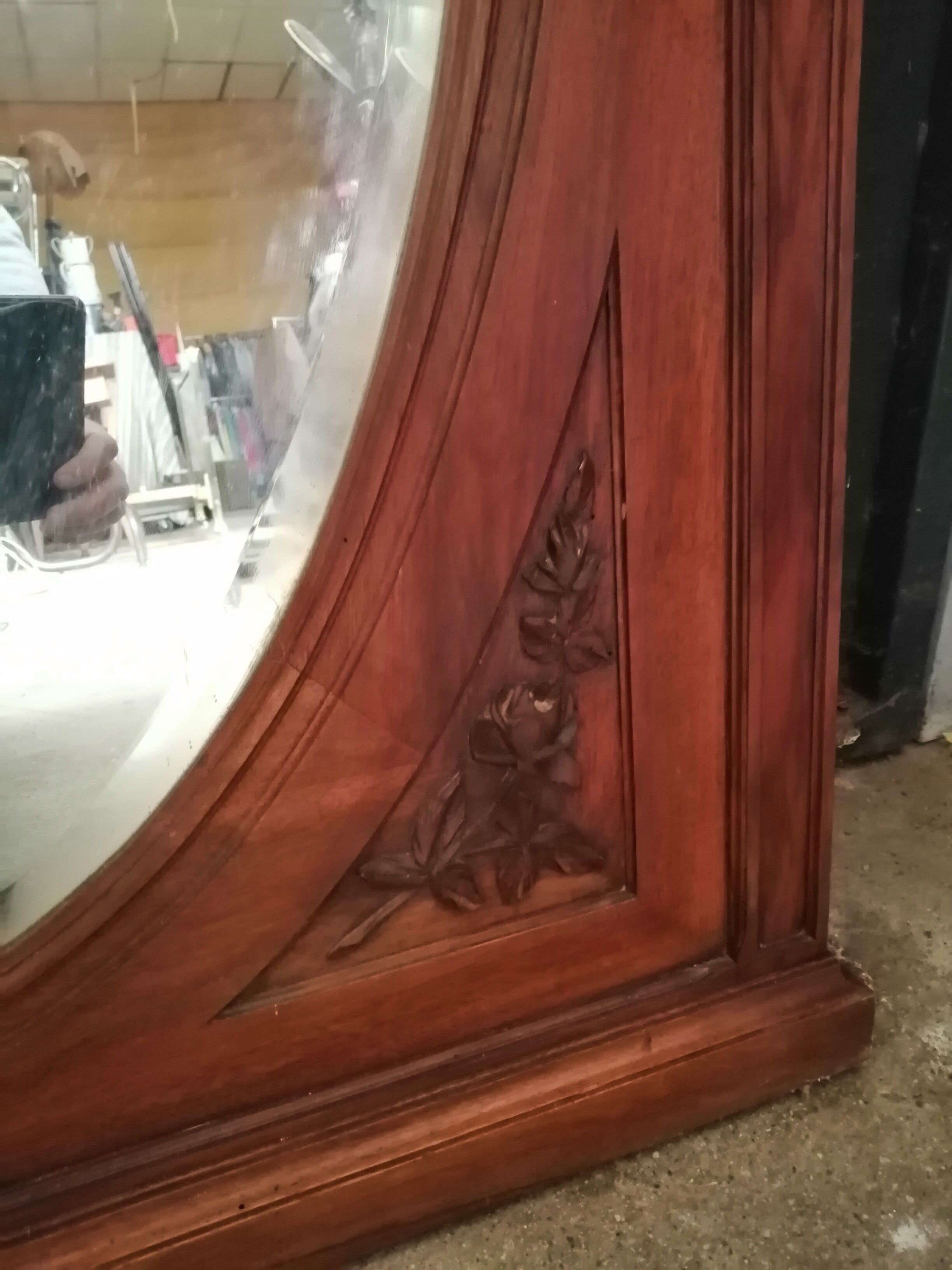 Old oval walnut wood mirror has flower carvings decoration