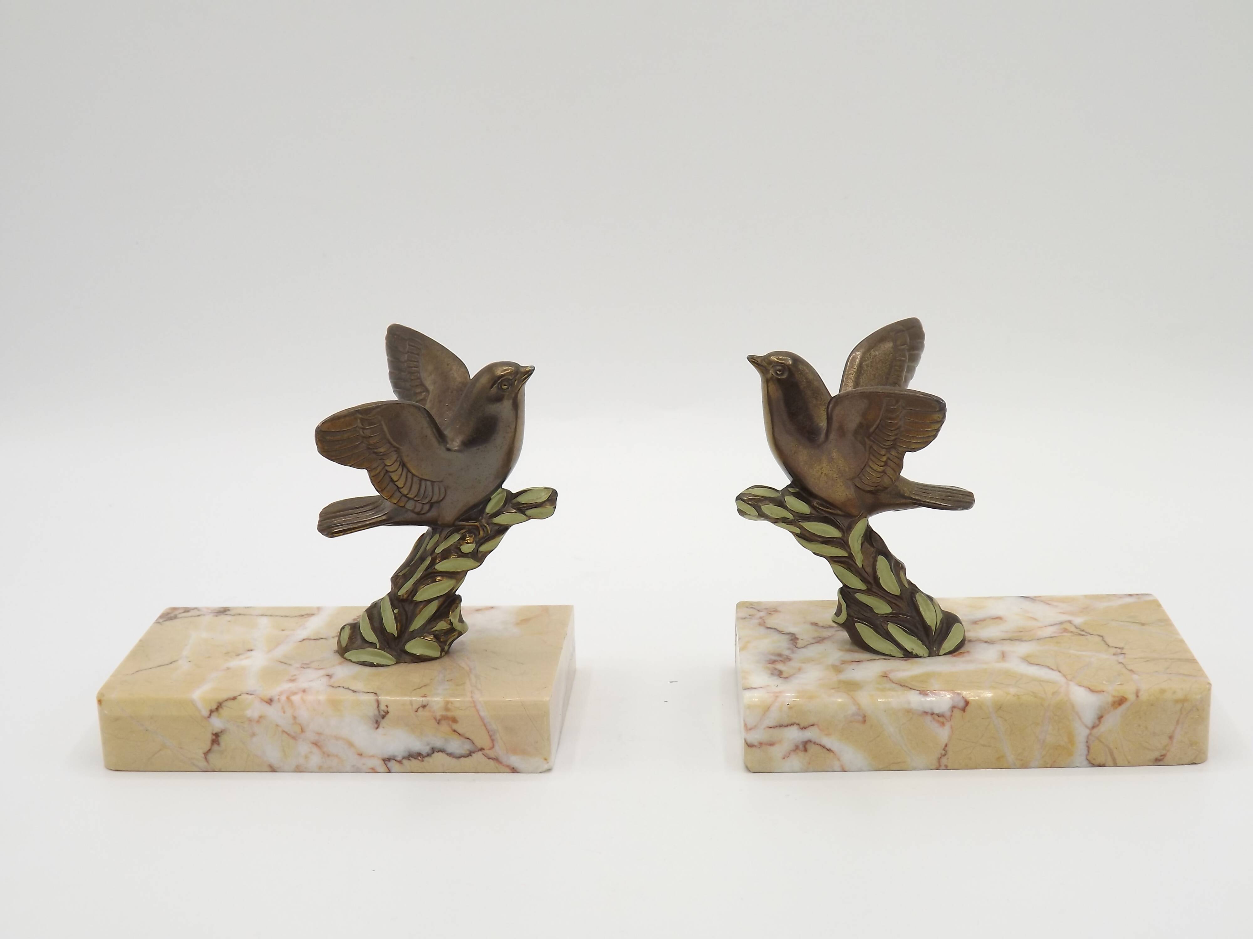 Paire de serre-livres Art déco français en étain représentant des oiseaux perchés sur une branche, socle en marbre