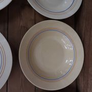 6 old cream-coloured deep plates with blue/orange trim.
