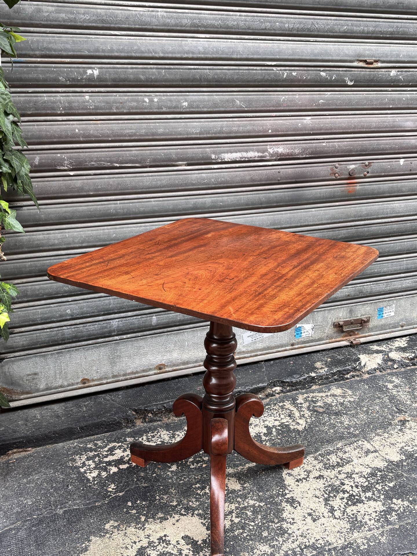 19th-century solid mahogany table with a tilting top and brass mechanism.