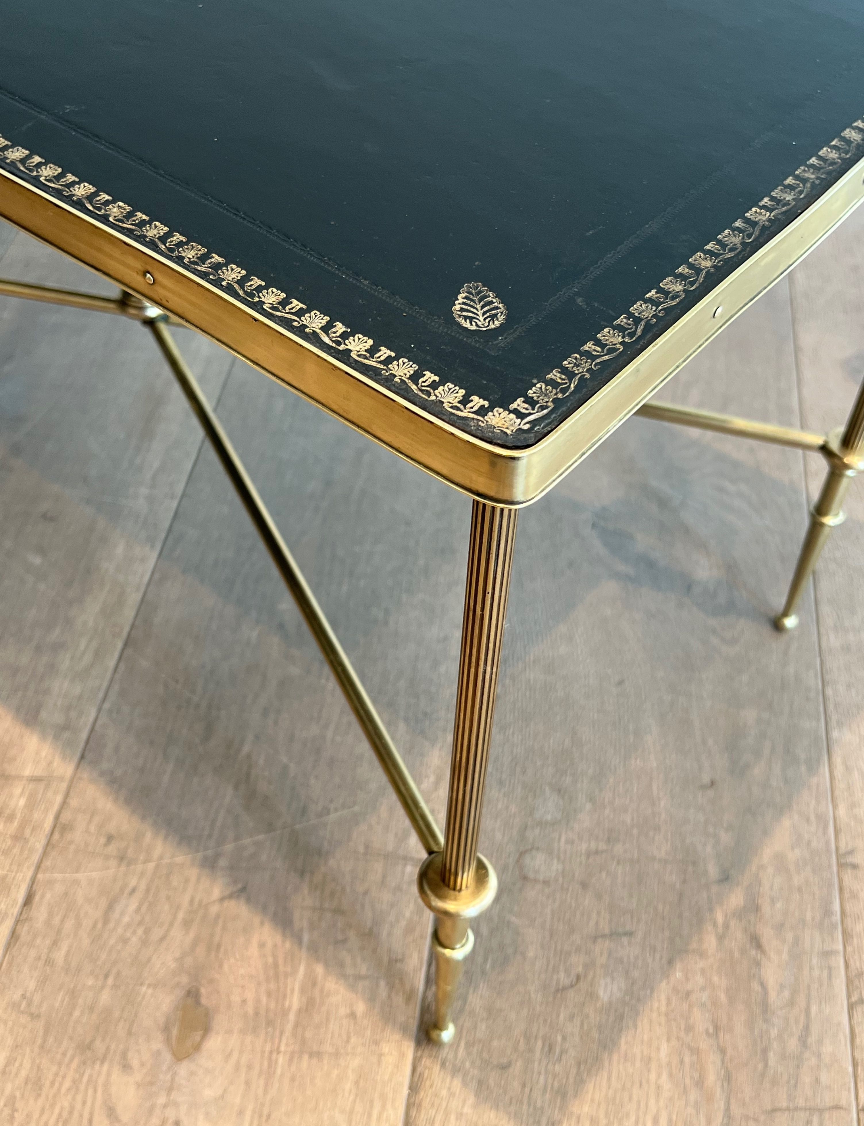 Neoclassical brass coffee table with a black leather top and golden borders from Maison Jansen.