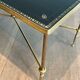 Neoclassical brass coffee table with a black leather top and golden borders from Maison Jansen.