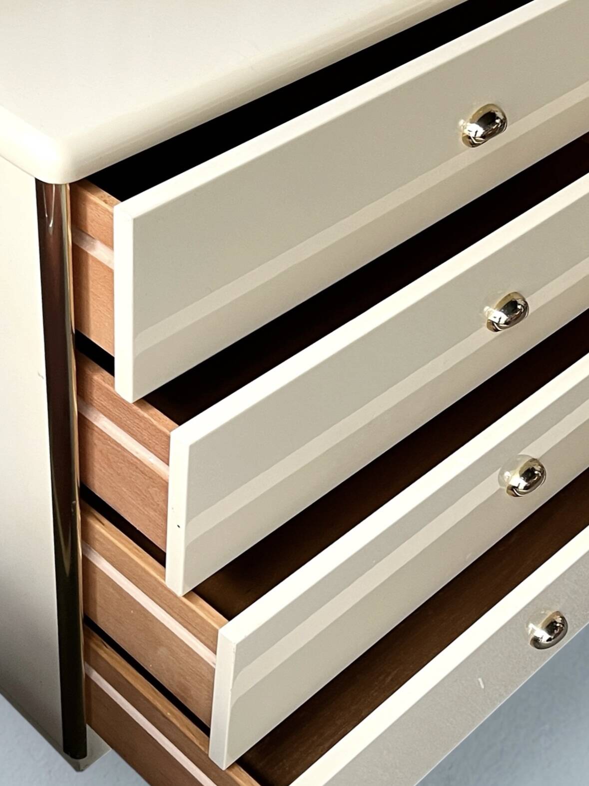 Commode type sideboard with 8 drawers, ivory lacquer and brass details, 1970s design.