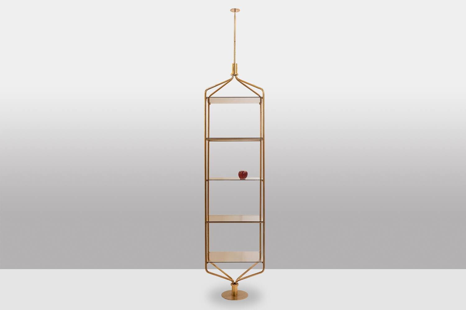 Free-standing shelf in gilded brass with smoked glass shelves. 1970s.