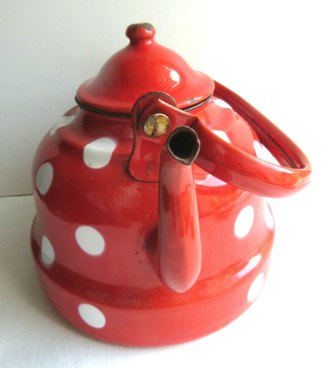 Old vintage kettle in red enamelled sheet metal, with white polka dots