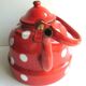 Old vintage kettle in red enamelled sheet metal, with white polka dots