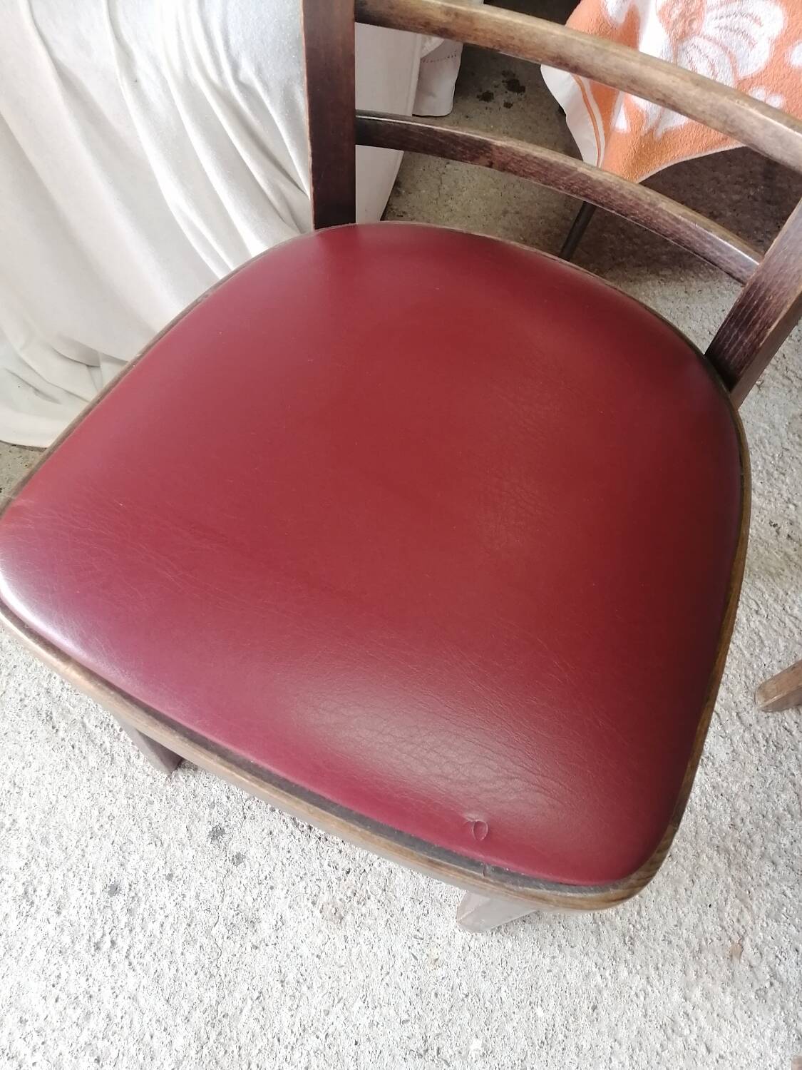 Set of 19 vintage wooden bistro chairs with red faux leather.