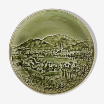 Old vintage plate in green earthenware landscape in relief