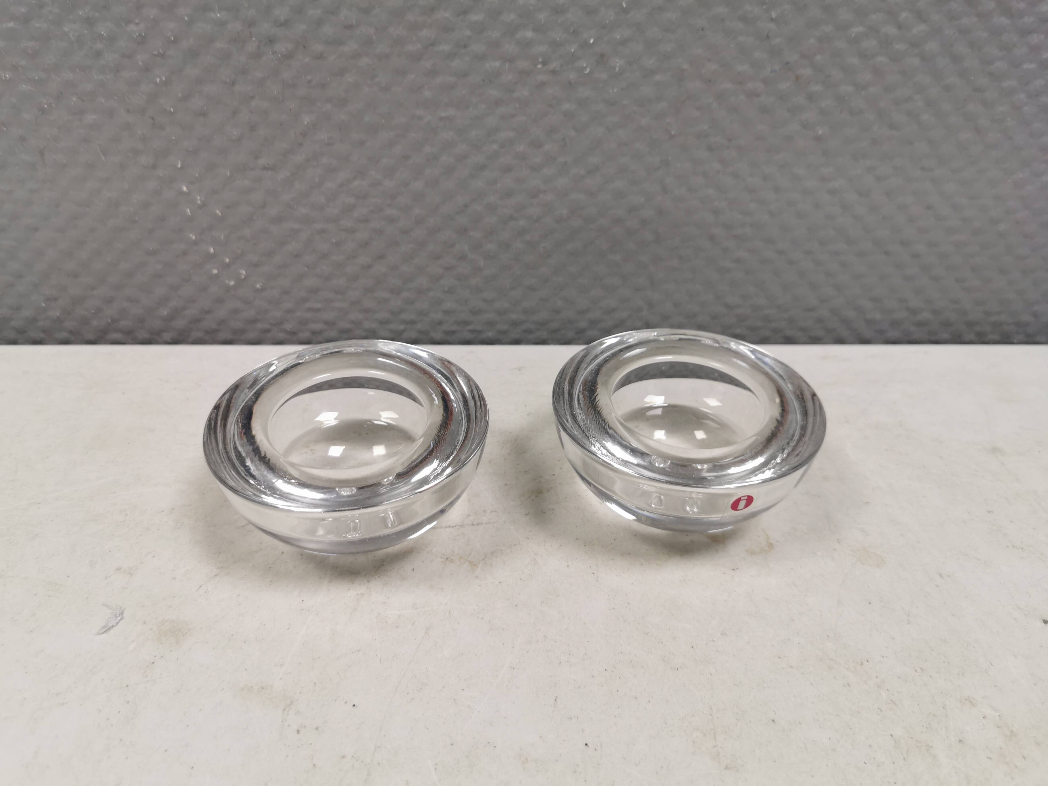 A set of iittala candle holders in clear transparent glass.