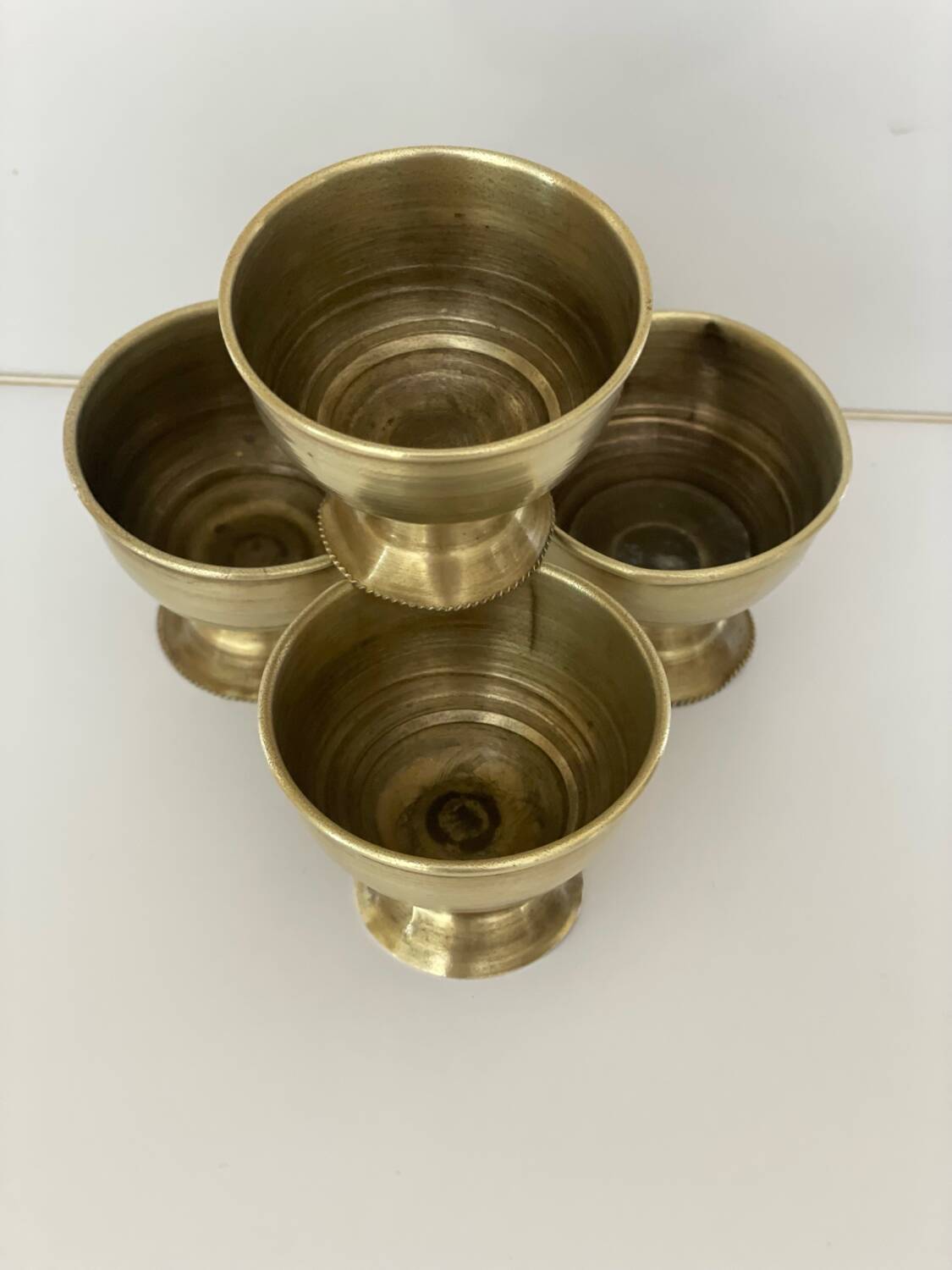 4 golden brass egg cups
