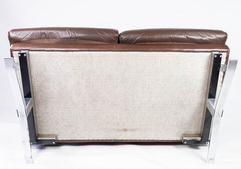 Two seater sofa upholstered with patinated brown leather and frame in metal, designed by Arne Norell