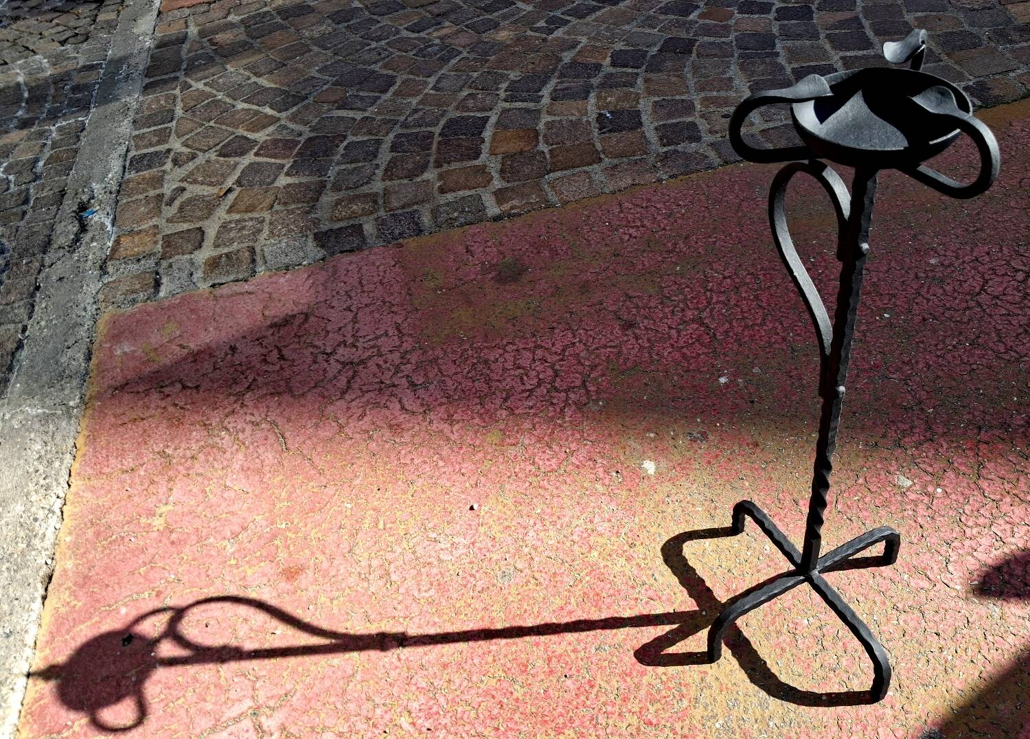 Old ashtray on twisted hammered wrought iron legs, vintage decor.