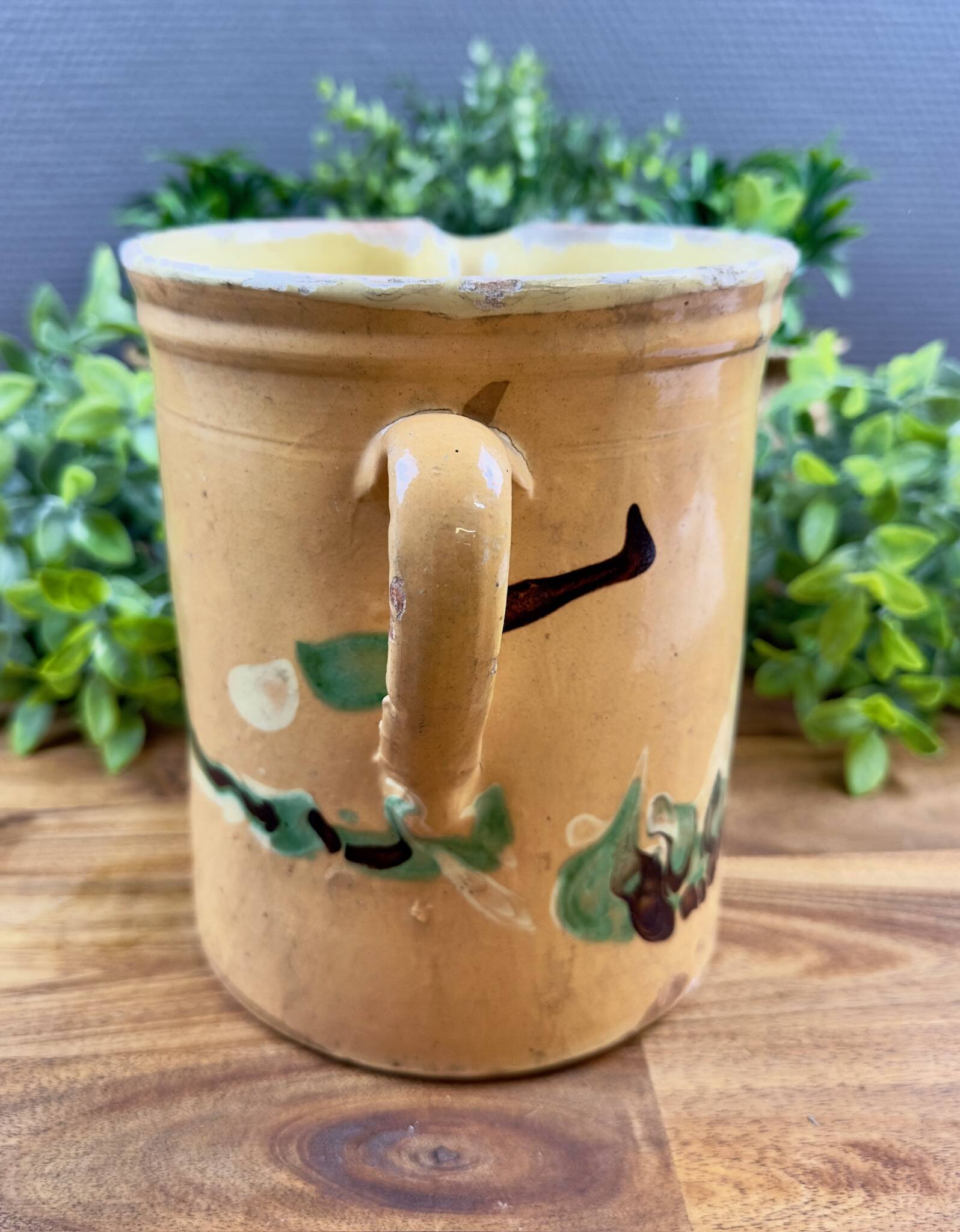 Large vintage ceramic pitcher with abstract green and brown decoration.