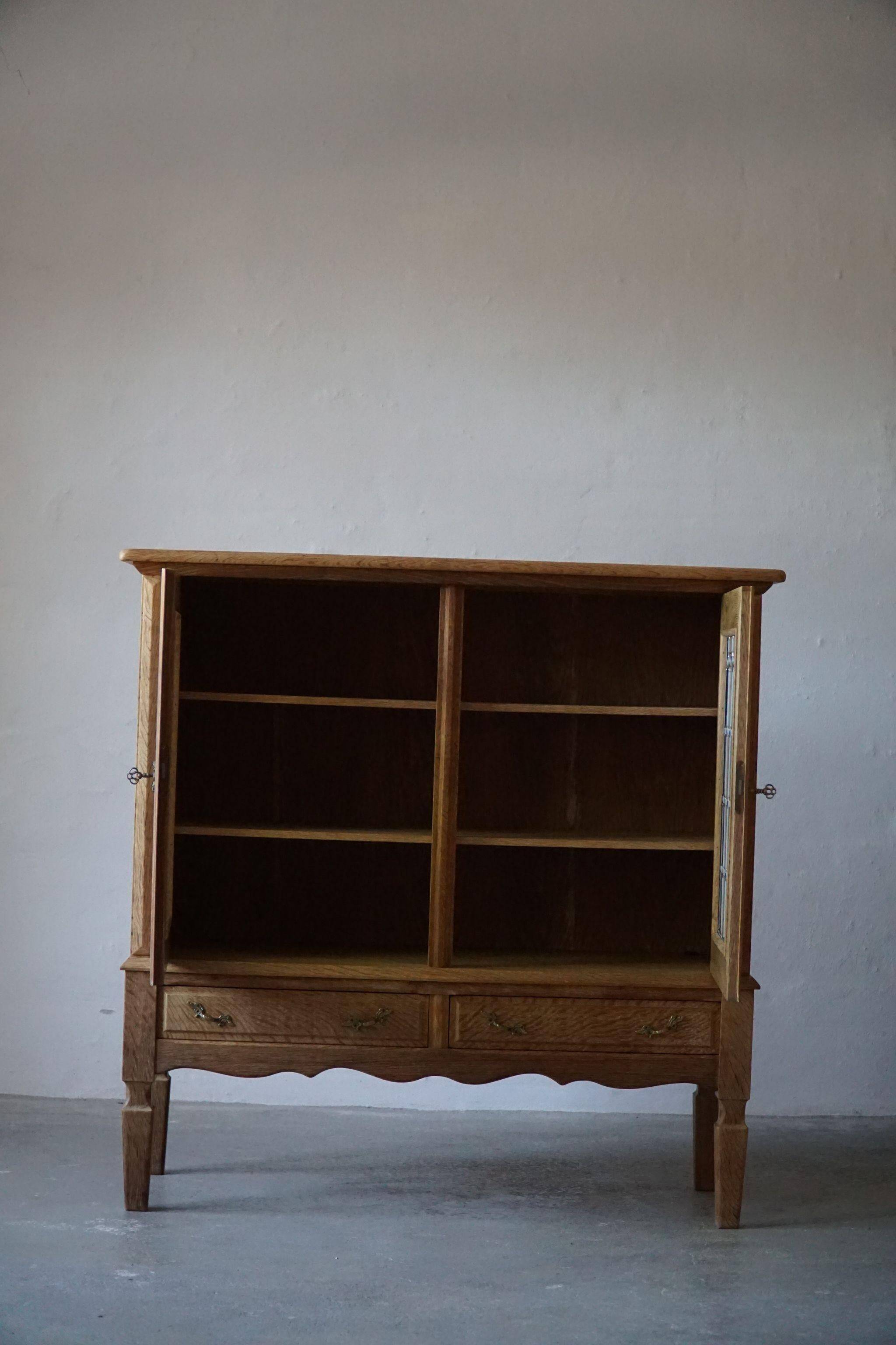 20th-century mid-century solid oak sideboard with glass front, by a Danish cabinetmaker.