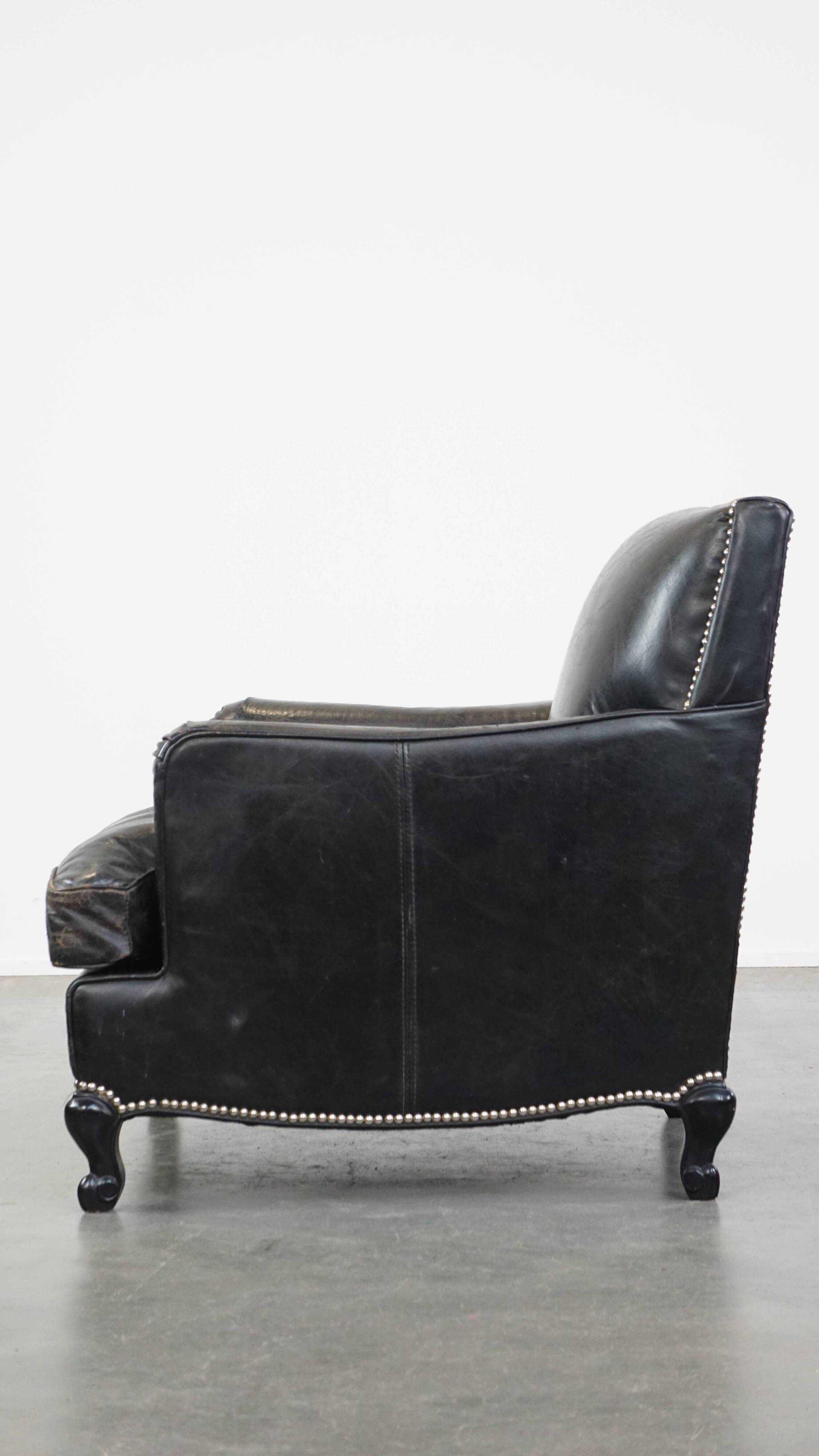 Armchair in black grained cowhide leather with a deep seat