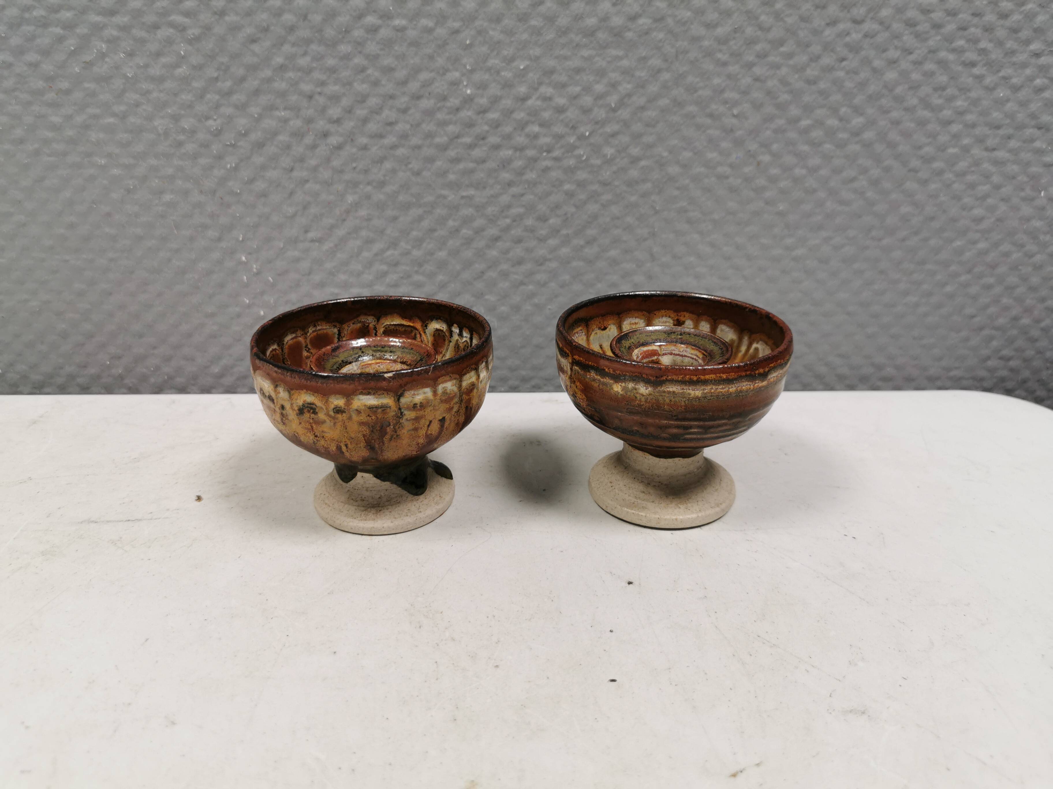 A set of ceramic candle holders in earthy colours.