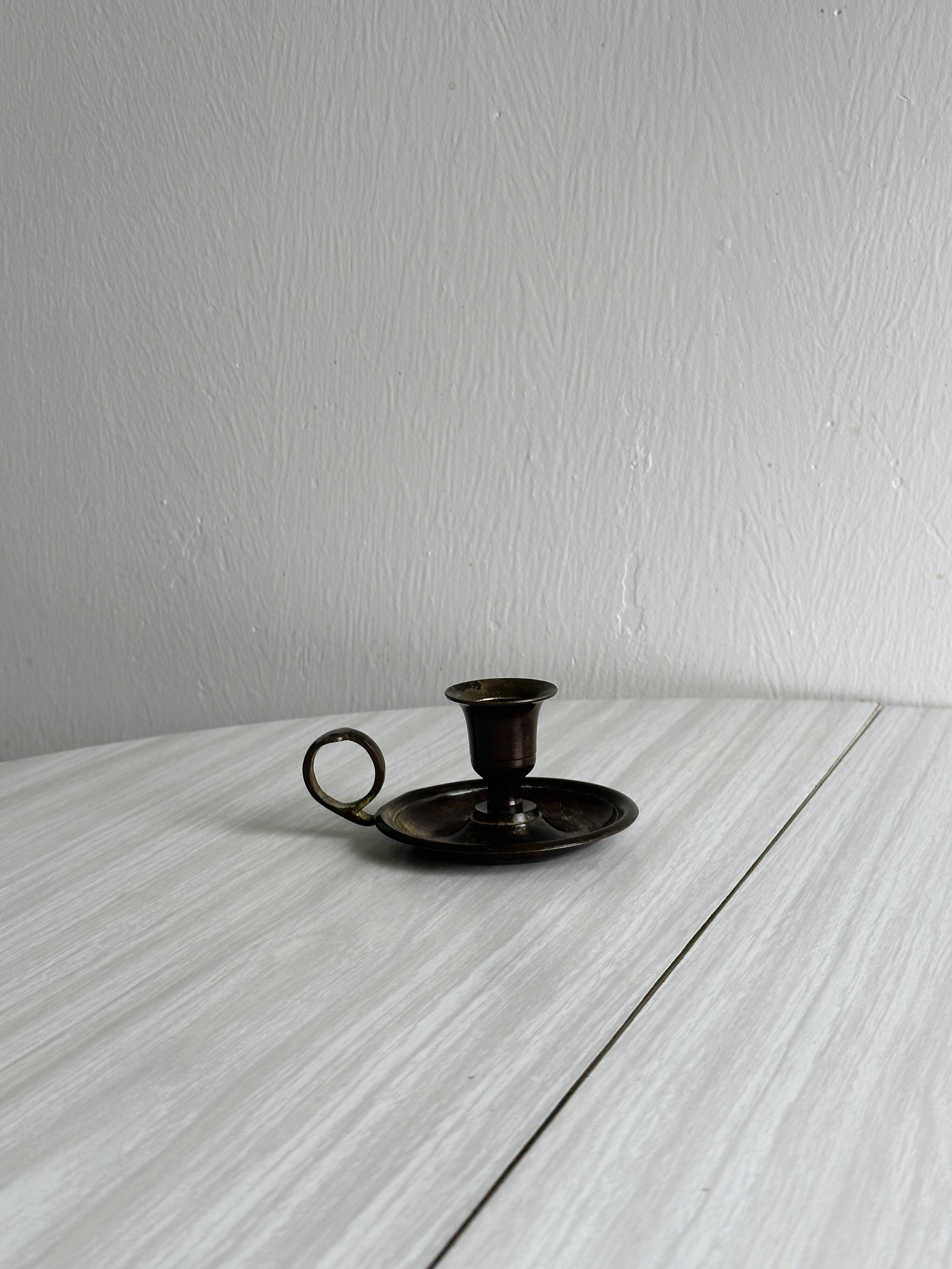 Small antique candle holder in patinated metal