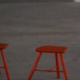 Pair of patinated wooden stools painted red with flared legs, 1950s-1960s.