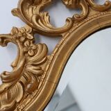 French Rococo or Baroque style facet-cut crest mirror in gilded carved wood