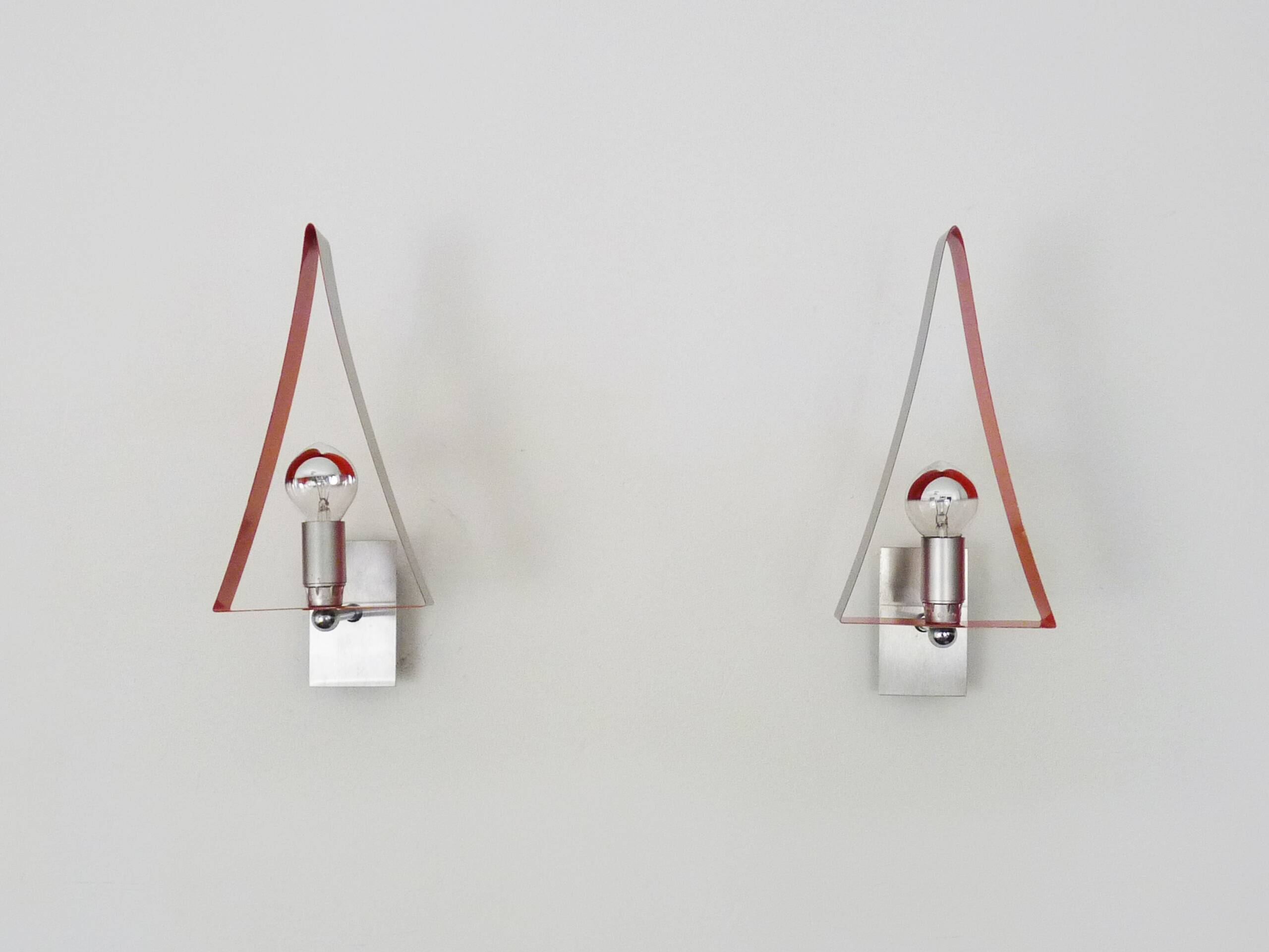 Pair of triangular wall sconces in chrome metal and orange. 1970s.