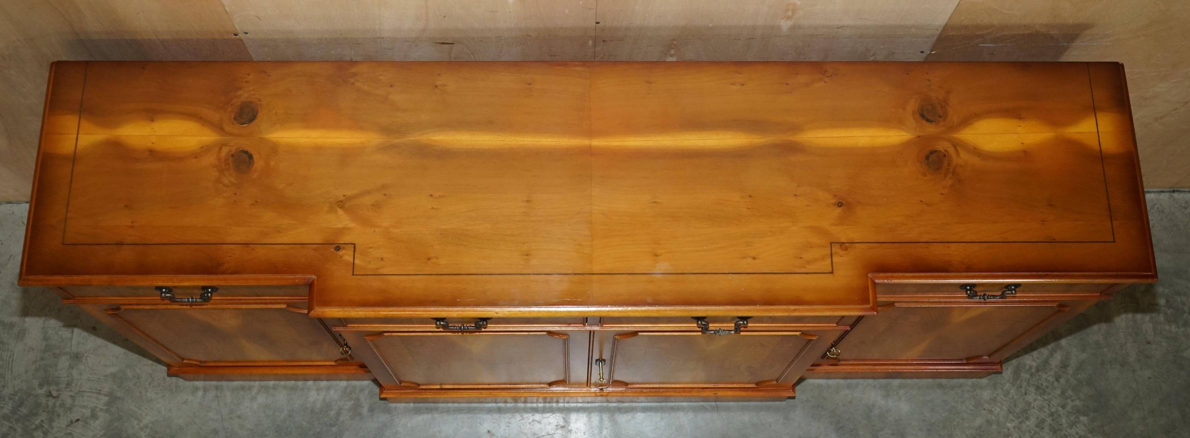 Vintage buffet made of mottled yew wood with three doors and four drawers.